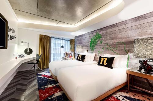伦敦nhow London的酒店客房带两张床和砖墙