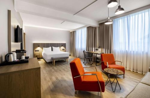 卢森堡卢森堡NH酒店的酒店客房设有床和客厅。