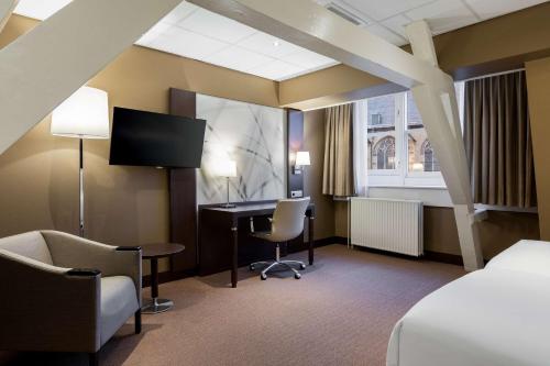 乌得勒支乌得勒支中心NH酒店的酒店客房设有一张床、一张书桌和一台电视机。