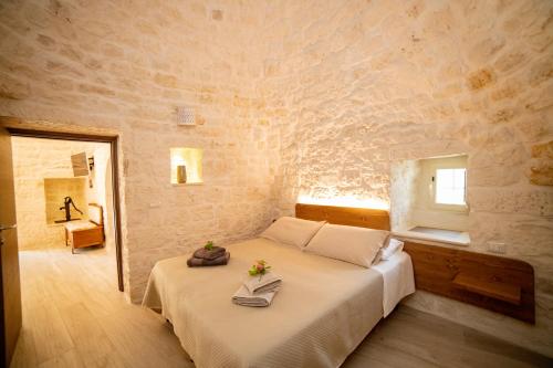 洛科罗通多Trulli Balè的卧室配有一张石墙床