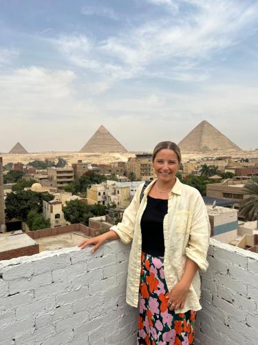 开罗LOAY PYRAMIDS VIEW的站在金字塔前墙上的女人