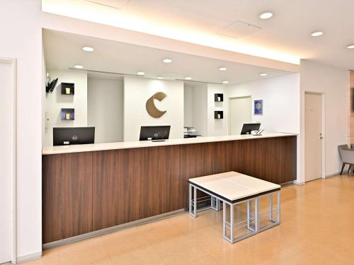 刈谷市刈谷舒适酒店的办公大厅,设有前台台,上面装有笔记本电脑