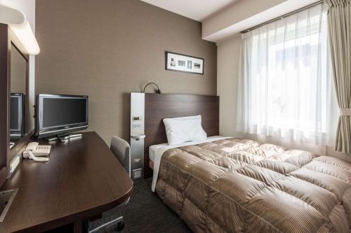钏路北海道康福特酒店的配有一张床和一张书桌的酒店客房