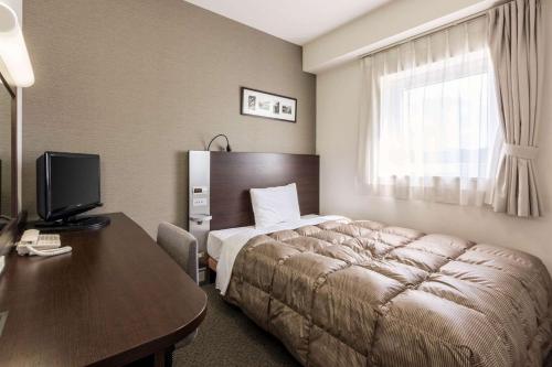 北上市北上康福特因酒店的酒店客房配有一张床和一张带电脑的书桌