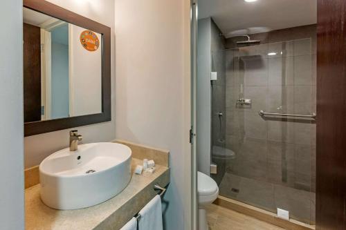 提华纳Sleep Inn Tijuana的白色的浴室设有水槽和淋浴。