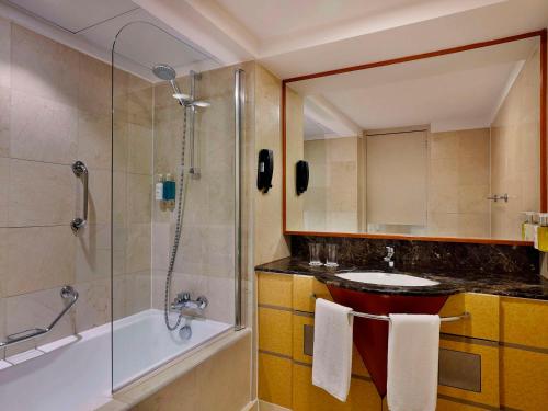 迪拜Queen Elizabeth 2 Hotel的带淋浴、盥洗盆和浴缸的浴室