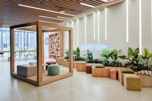 迪拜First Class 1BR Apartment in Dubai Hills - next to Dubai Hills Mall的大堂里摆放着一排椅子和植物