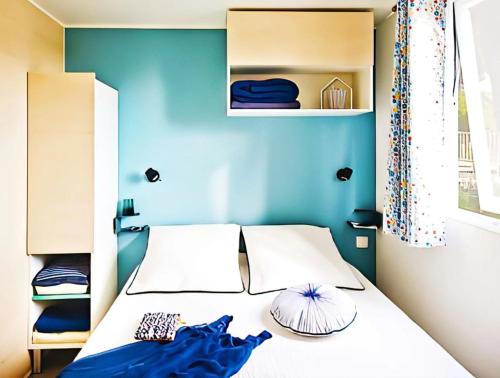 Canet-de-SalarsMobilhome 3 étoiles - efb0fi的一间卧室配有一张蓝色墙壁的床