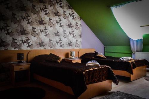 Rymanów伯格马宾馆的绿墙客房内的两张床