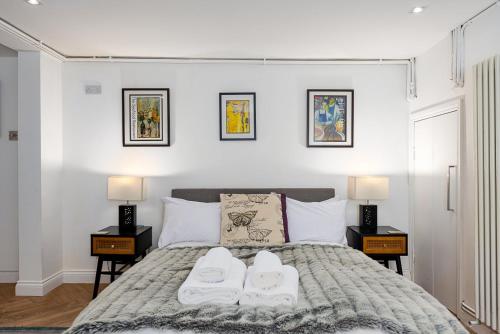 伦敦GuestReady - Charming studio in Hackney的一间卧室配有一张带白色毛巾的床