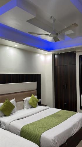新德里Hotel Classic Suites的卧室内的两张床,配有吊扇