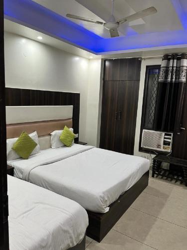 新德里Hotel Classic Suites的蓝色灯的酒店客房内的两张床