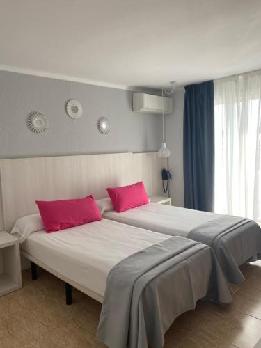 卡拉费尔索利马尔公寓酒店的一间卧室配有两张带红色枕头的床