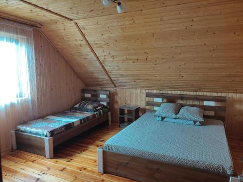 斯维季亚济Сімейний куточок的小木屋内一间卧室,配有两张床