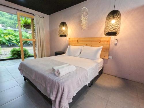 米卡Hotel Casa de Hadas的一间卧室配有一张带白色床单的床和一扇窗户。