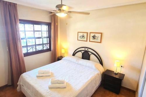 圣米格尔德阿沃纳Precioso acogedor apartamento Parque Albatros 272的一间卧室配有一张床,上面有两条毛巾