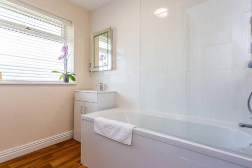 蒂斯河畔斯托克顿3Bedroom House Stockton On Tees for Work & Leisure的白色的浴室设有浴缸和窗户。