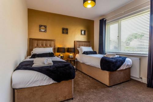蒂斯河畔斯托克顿3Bedroom House Stockton On Tees for Work & Leisure的一间卧室设有两张床和窗户。