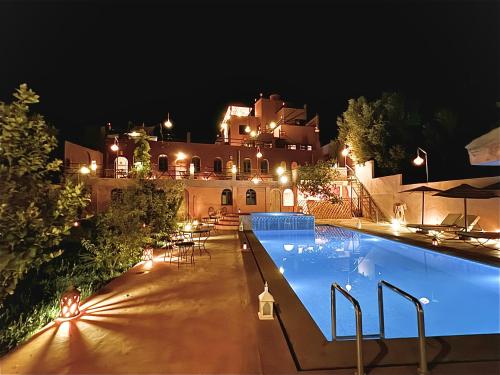 布马伦Riad Sahara Stars Dades的一座在晚上设有游泳池的大房子