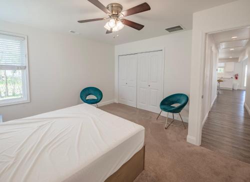 五月岬郡Sun Outdoors Cape May的白色卧室配有两把椅子和一张床