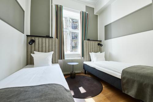 哥本哈根斯卡特托马斯酒店的酒店客房设有两张床和窗户。