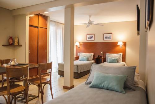 科连特斯DonSuites的一间酒店客房,配有两张床和一张餐桌