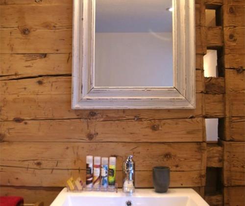 安德马特Boutique Hotel The River House的浴室设有水槽和木墙镜子