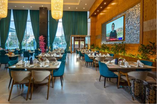 吉达Donatello Jeddah Hotel的一间配备有桌子和蓝色椅子的用餐室