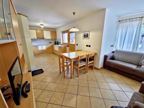 卡纳泽伊Alpe Di Gries Sella Ronda Dolomiti的厨房以及带桌子和沙发的客厅。