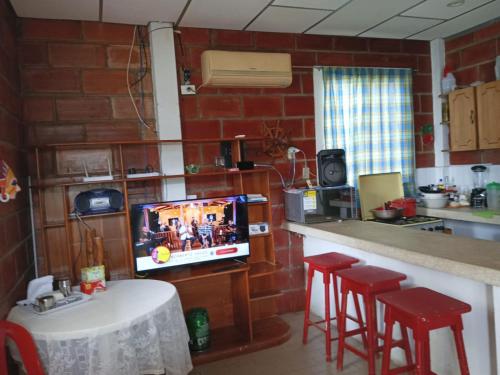 普拉亚斯A orillas del paraiso的厨房配有电视和带凳子的台面