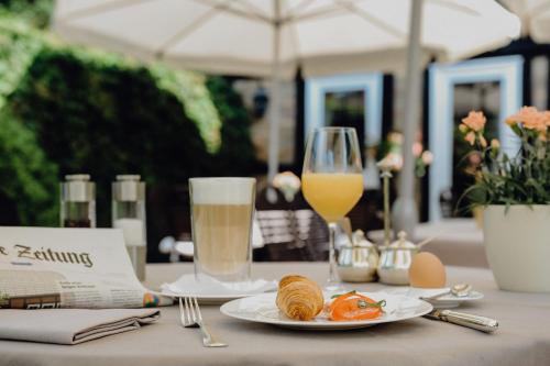 策勒考尔奈斯兰德豪斯罗曼蒂克酒店的一张桌子,上面放着一盘食物和一杯橙汁