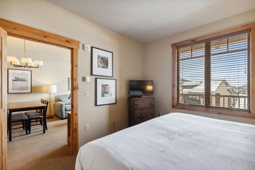 白鱼镇Morning Eagle 207的一间卧室配有一张床、一张书桌和一个窗户。