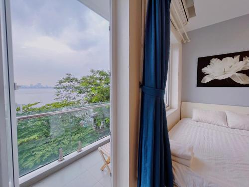 河内Hanoi Home 2 - Lake View Apartment的一间卧室设有窗户和一张床,享有美景
