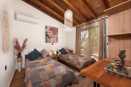 根纳迪Ilaira Sea View Bungalow的一间卧室设有两张床、一张桌子和一个窗口