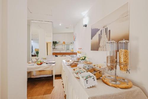 波尔图·埃尔科莱碧酒店的一间白色的房间,配有桌子和食物