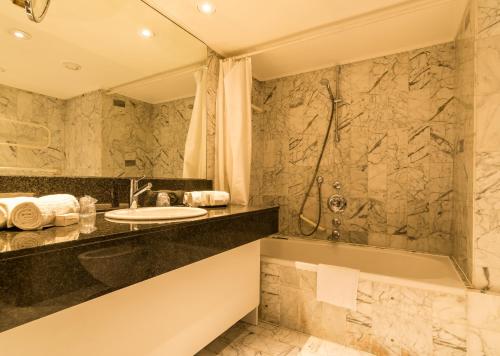 安特卫普阿尔法德基瑟酒店的浴室配有水槽、淋浴和浴缸。