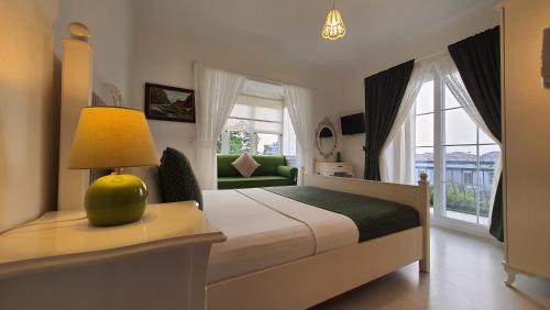 阿拉恰特阿德尔菲亚酒店的一间卧室配有一张带灯和沙发的床