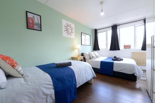 伦敦3 BEDROOM FLAT IN CENTRAL LONDON - REGENTS PARK / BAKER ST的一间卧室设有两张床和窗户。