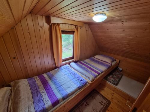 Koprivnik v BohinjuLodge In Koprivnik的小屋内的一张小床,设有窗户