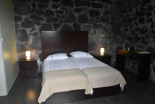 韦拉斯Casa da Ermida的一间卧室配有一张带2个床头柜的大床