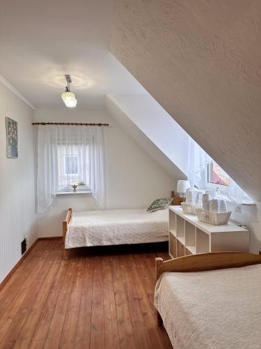 米科瓦伊基Apartament Mazurskie Ciepło的阁楼卧室设有两张床和窗户。