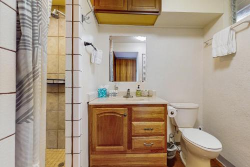 科纳Kona Magic Sands 107的一间带水槽、卫生间和镜子的浴室