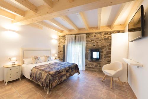 圣地亚哥－德孔波斯特拉Landras de Compostela的一间卧室,卧室内配有一张床和一把椅子