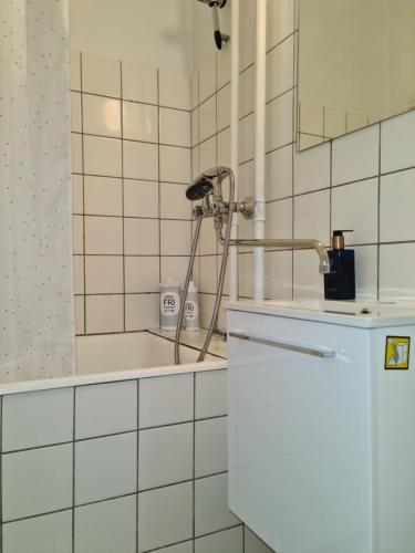 RødovreBayer Apartments Copenhagen的白色瓷砖浴室设有小冰箱