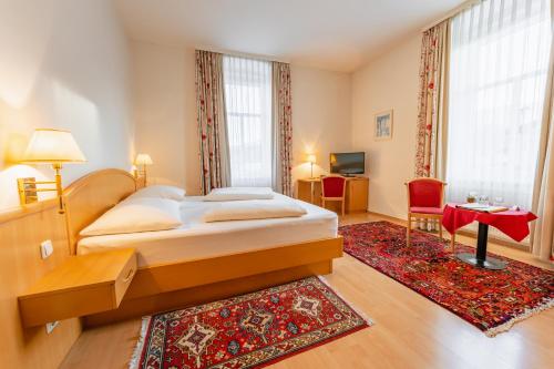 塞博登波斯特尔酒店的一间卧室配有一张大床和红色地毯。