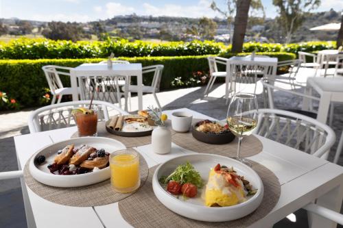 卡尔斯巴德Omni La Costa Resort & Spa Carlsbad的餐桌,带食物盘和酒杯