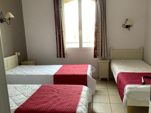 格罗斯皮耶尔雷Duplex (5pers) dans village vacances en Ardèche的一间卧室配有两张带红白毯子的床