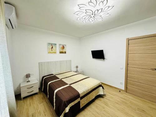 迈阿密普拉特亚Villa “Castellón“的一间卧室配有一张床和一个吊灯