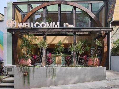 麦德林Wellcomm Spa & Hotel的植物建筑前的商店
