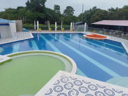 TauramenaHotel Campestre Morichal的旁边设有长凳的大型蓝色游泳池